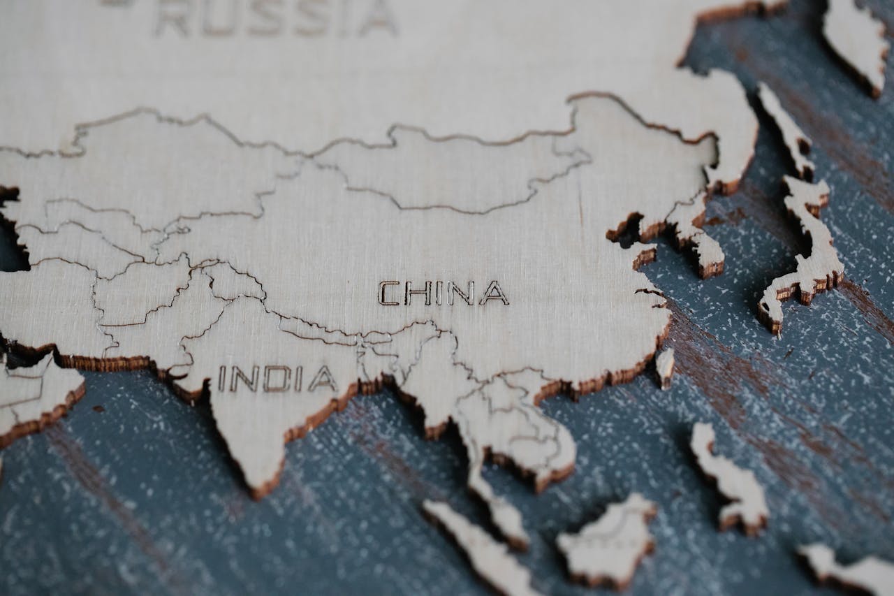 Detailed view of Asia carved on a wooden map, highlighting China and India.